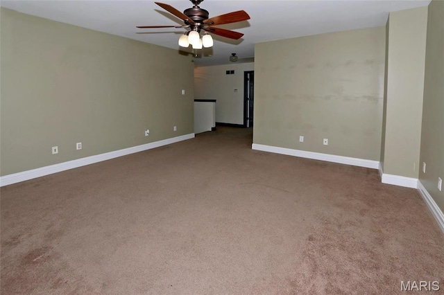 empty room featuring carpet floors, a ceiling fan, and baseboards