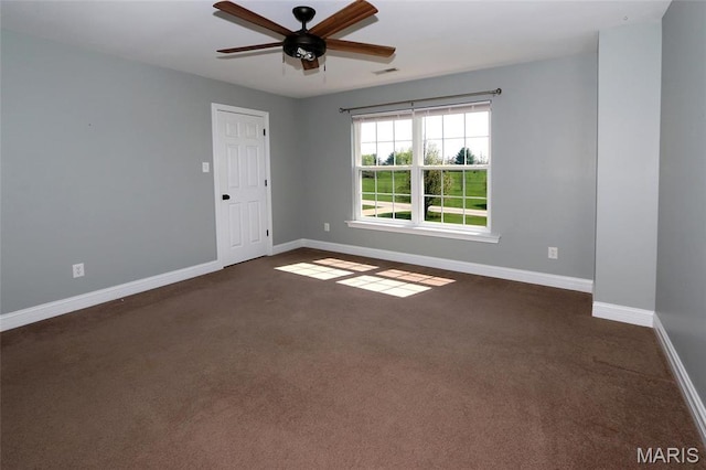 spare room featuring a ceiling fan, baseboards, and dark colored carpet