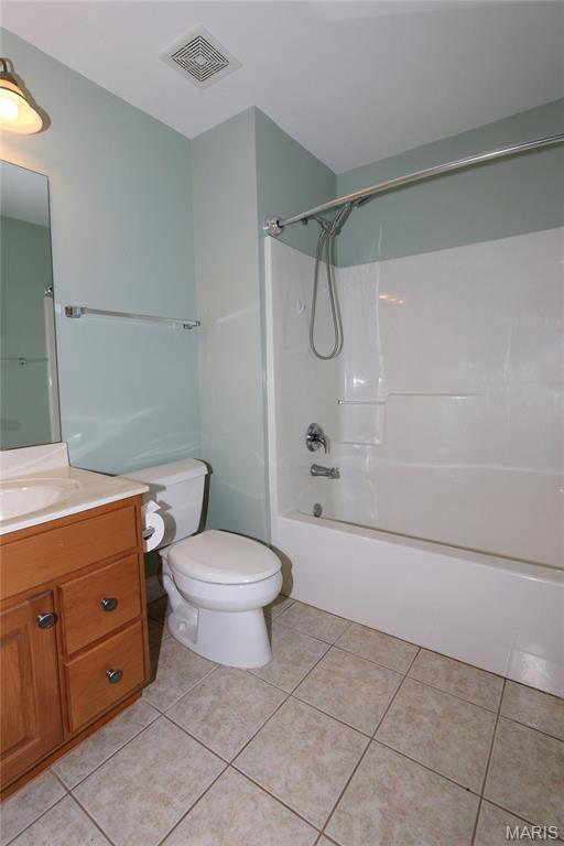 bathroom with tile patterned flooring, vanity, toilet, and shower / bathtub combination