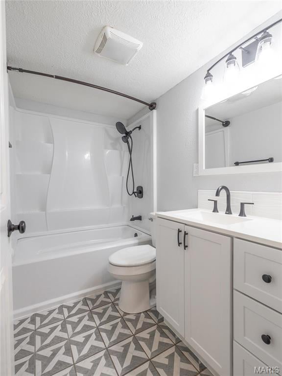 full bath featuring a textured ceiling, toilet, shower / washtub combination, and vanity
