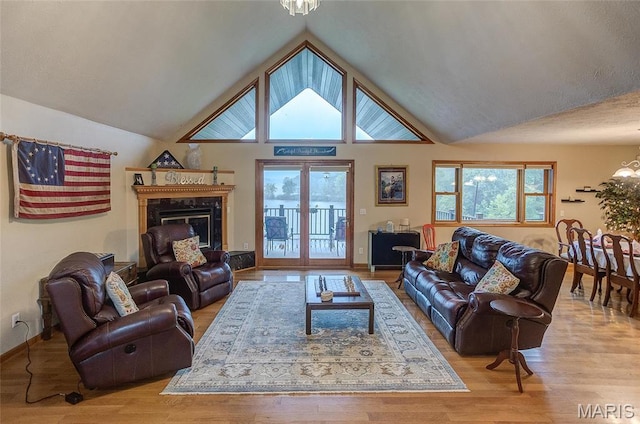 3448 Levee Rd, Centralia, IL 62801 - living room with a chandelier, light wood-type flooring, lofted ceiling, baseboards, and a fireplace