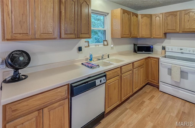 3448 Levee Rd, Centralia, IL 62801 - kitchen with white appliances, light wood-type flooring, light countertops, a sink, and brown cabinets