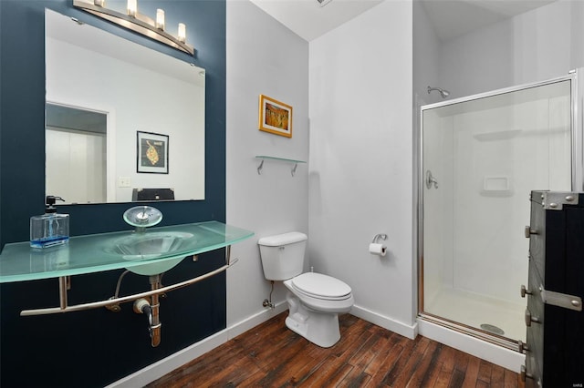 full bath with wood finished floors, baseboards, toilet, and a shower stall