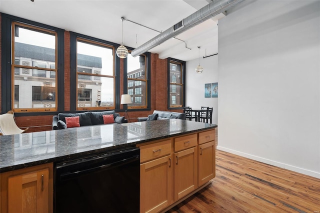 kitchen with black dishwasher, wood finished floors, baseboards, and pendant lighting