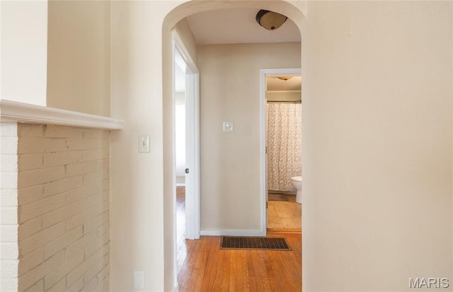 11 Rolla Gardens Dr, Rolla, MO 65401 - hallway featuring wood finished floors, arched walkways, and baseboards