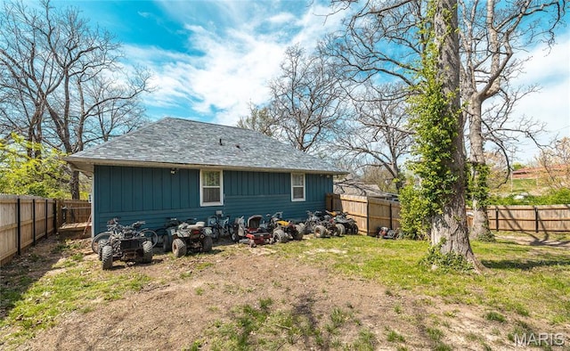 11 Rolla Gardens Dr, Rolla, MO 65401 - rear view of property featuring a fenced backyard, a shingled roof, and board and batten siding