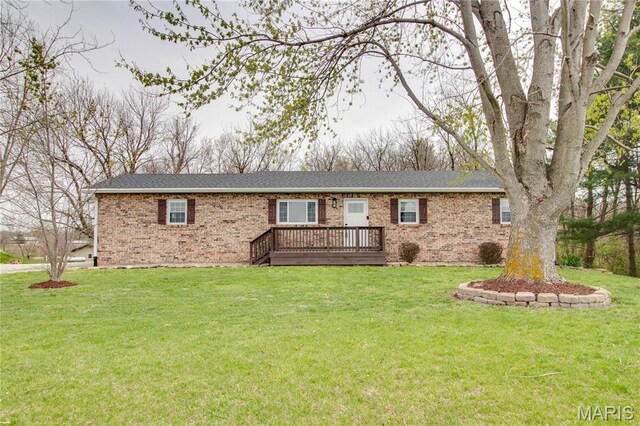view of front of property featuring brick siding, a wooden deck, and a front yard