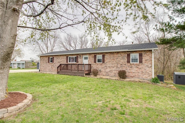 back of house featuring a wooden deck, a lawn, and brick siding