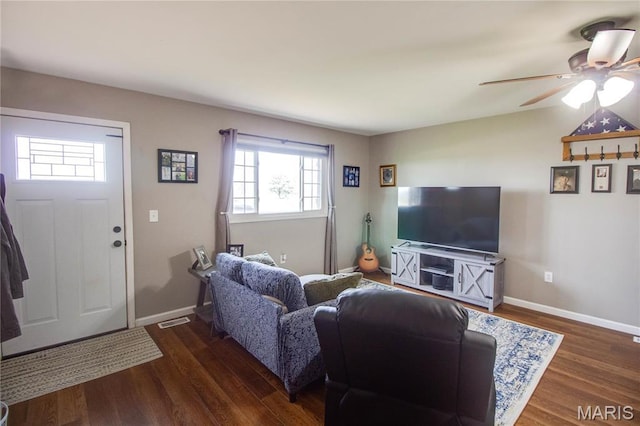 living room featuring wood finished floors, a ceiling fan, and baseboards