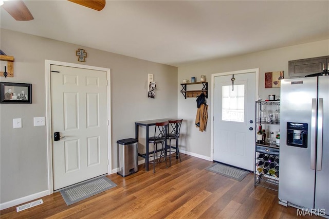 entryway featuring a ceiling fan, wood finished floors, and baseboards