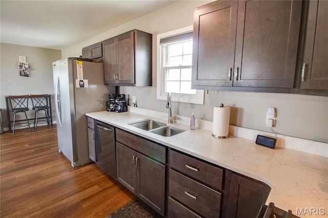 kitchen featuring a sink, stainless steel appliances, light countertops, dark wood-style floors, and dark brown cabinets