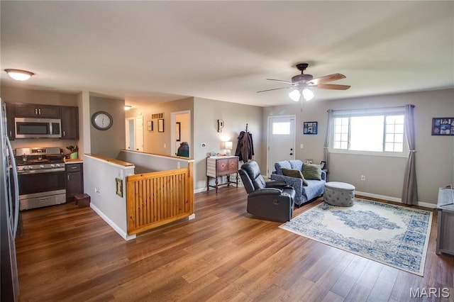living area featuring wood finished floors, ceiling fan, and baseboards
