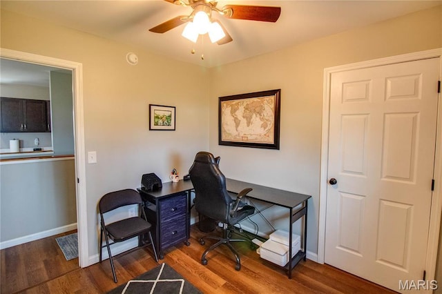 office space featuring a ceiling fan, wood finished floors, and baseboards