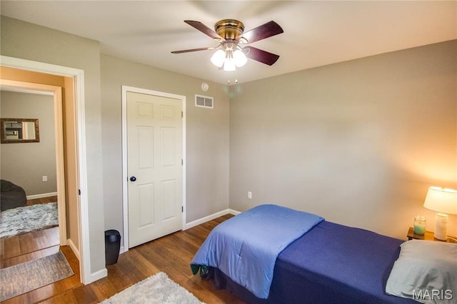 bedroom featuring wood finished floors, baseboards, and a ceiling fan