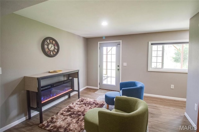 sitting room with healthy amount of natural light, baseboards, wood finished floors, and recessed lighting