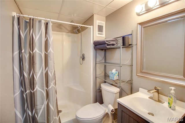 full bathroom with a shower stall, toilet, vanity, and a paneled ceiling