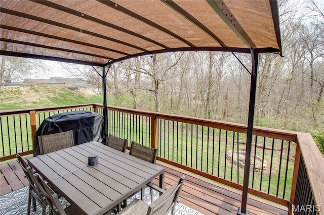 wooden deck featuring a pergola, outdoor dining space, a grill, and a lawn