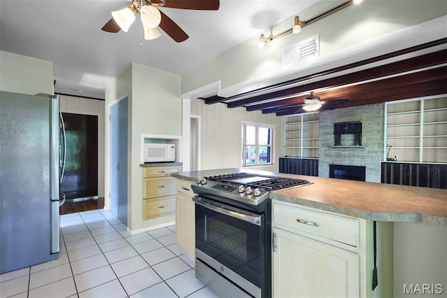 135 Hollyhock Ln, Edwardsville, IL 62025 - kitchen with appliances with stainless steel finishes, ceiling fan, light tile patterned floors, and a stone fireplace