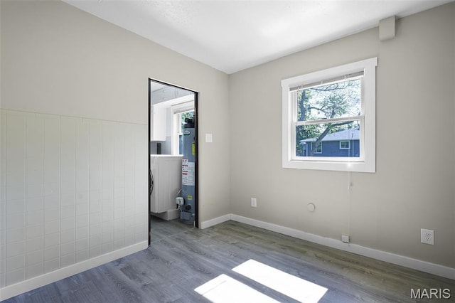 135 Hollyhock Ln, Edwardsville, IL 62025 - unfurnished bedroom featuring water heater, wood finished floors, baseboards, and washer / clothes dryer