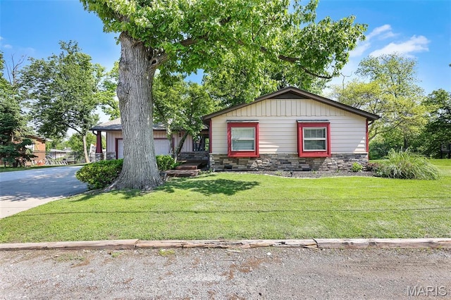 135 Hollyhock Ln, Edwardsville, IL 62025 - view of front of house with stone siding, driveway, a front yard, and a garage