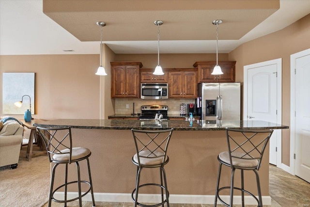 18011 Blue Anchor Dr Unit 132, Gravois Mills, MO 65037 - kitchen featuring stainless steel appliances, a breakfast bar, tasteful backsplash, an island with sink, and hanging light fixtures
