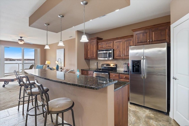 18011 Blue Anchor Dr Unit 132, Gravois Mills, MO 65037 - kitchen featuring appliances with stainless steel finishes, a breakfast bar area, backsplash, a center island with sink, and dark stone countertops