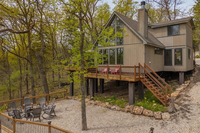 2099 Meadow Valley Dr, Innsbrook, MO 63390 - back of house with a deck, a fire pit, a shingled roof, stairway, and a chimney