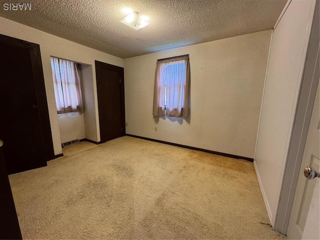 13899 Riverview Dr, New London, MO 63459 - unfurnished bedroom with light colored carpet, a textured ceiling, and baseboards