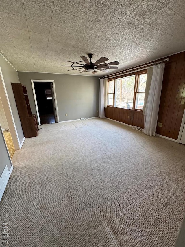 13899 Riverview Dr, New London, MO 63459 - spare room with a ceiling fan, light carpet, baseboards, and wooden walls