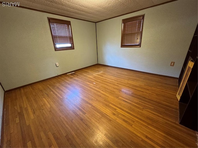 13899 Riverview Dr, New London, MO 63459 - empty room featuring a textured wall, wood-type flooring, and baseboards