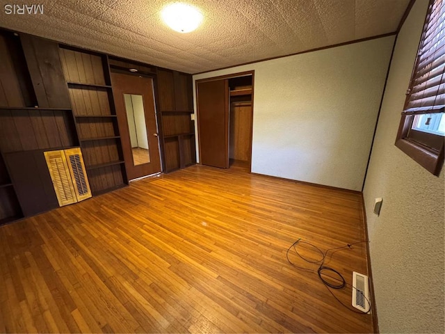 13899 Riverview Dr, New London, MO 63459 - unfurnished bedroom featuring a textured wall, light wood-type flooring, and a closet