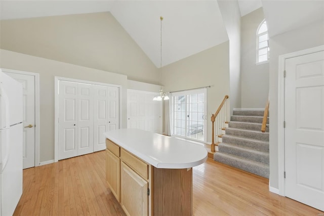 7426 Whitehall Colonial Ln, Saint Louis, MO 63119 - kitchen with high vaulted ceiling, light wood finished floors, light countertops, plenty of natural light, and a chandelier