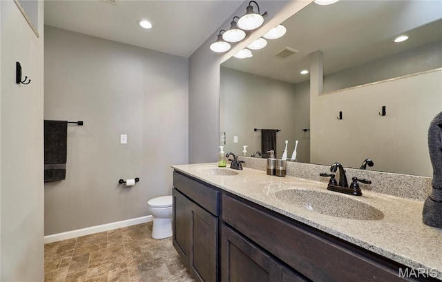 34 Moore Estates Ct, Troy, MO 63379 - full bath with baseboards, toilet, double vanity, stone finish flooring, and recessed lighting