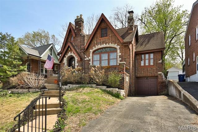 7414 Bruno Ave, Saint Louis, MO 63117 - tudor house with brick siding, a chimney, and asphalt driveway