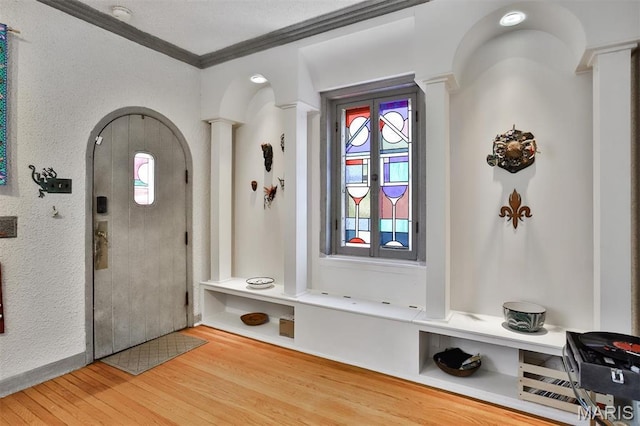 7414 Bruno Ave, Saint Louis, MO 63117 - foyer entrance with ornate columns, wood finished floors, ornamental molding, arched walkways, and a textured wall