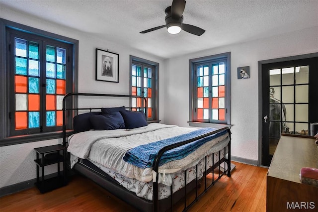 7414 Bruno Ave, Saint Louis, MO 63117 - bedroom featuring a textured ceiling, wood finished floors, baseboards, and ceiling fan
