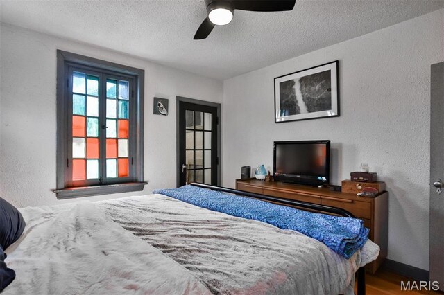 7414 Bruno Ave, Saint Louis, MO 63117 - bedroom with a textured ceiling, wood finished floors, baseboards, a textured wall, and ceiling fan