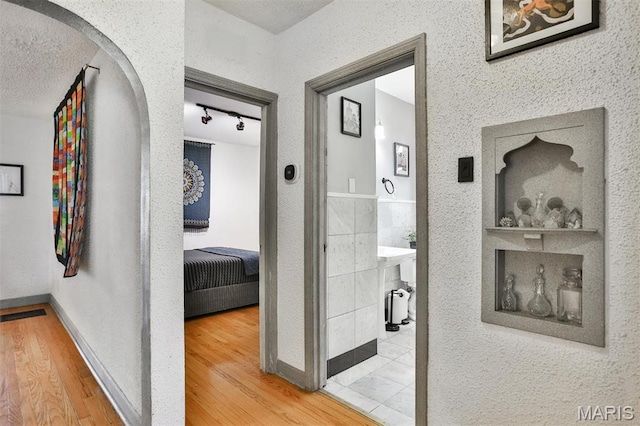 7414 Bruno Ave, Saint Louis, MO 63117 - hall with arched walkways, wood finished floors, and track lighting