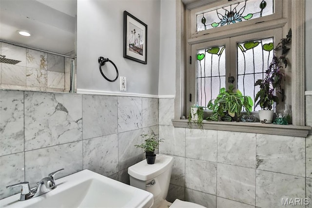 7414 Bruno Ave, Saint Louis, MO 63117 - bathroom featuring toilet, a sink, tile walls, and french doors