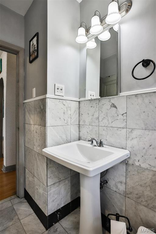 7414 Bruno Ave, Saint Louis, MO 63117 - bathroom featuring tile walls, a sink, and wainscoting