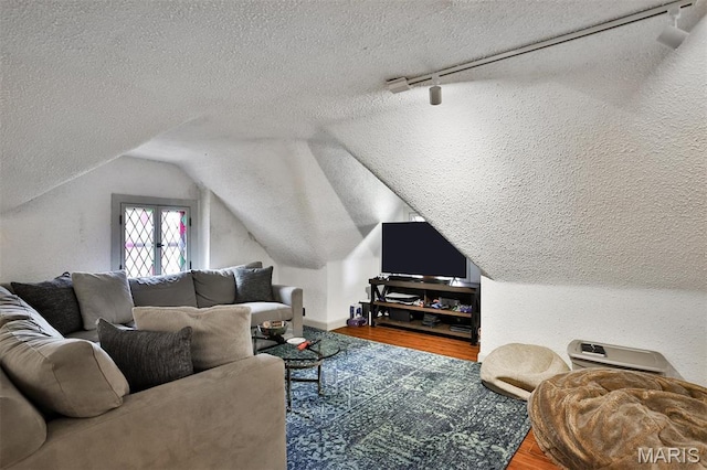 7414 Bruno Ave, Saint Louis, MO 63117 - living room with a textured ceiling, wood finished floors, lofted ceiling, track lighting, and baseboards