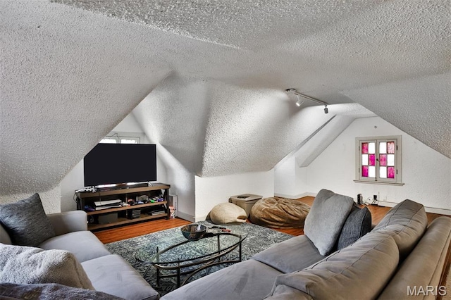 7414 Bruno Ave, Saint Louis, MO 63117 - living area with a textured ceiling, wood finished floors, track lighting, lofted ceiling, and baseboards