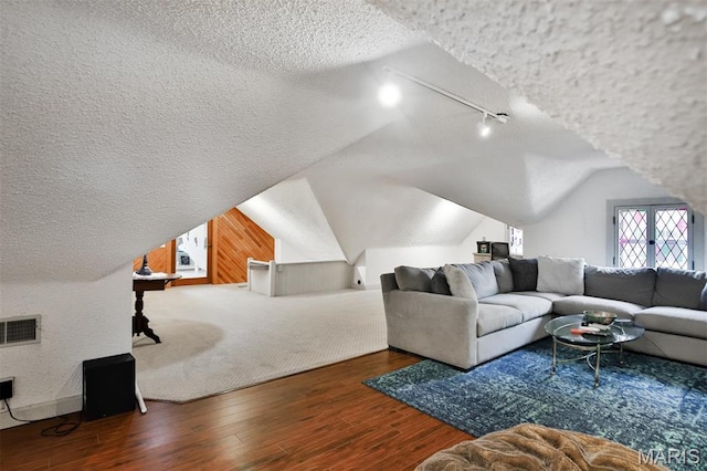 7414 Bruno Ave, Saint Louis, MO 63117 - living room featuring a textured ceiling, wood finished floors, rail lighting, and vaulted ceiling