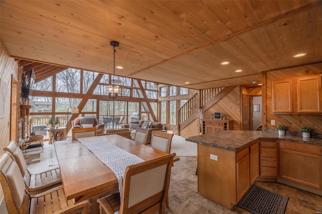 dining space with wood ceiling, wood walls, and a chandelier