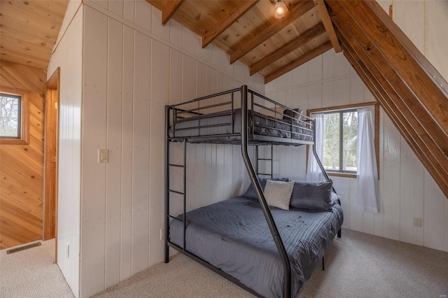 bedroom with carpet flooring, wooden walls, and wood ceiling