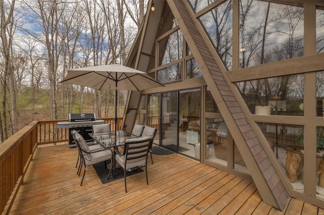 wooden terrace with area for grilling and outdoor dining space