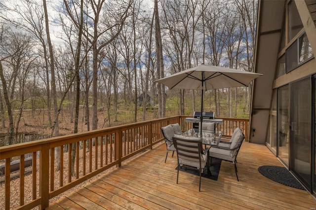 deck with outdoor dining space and area for grilling