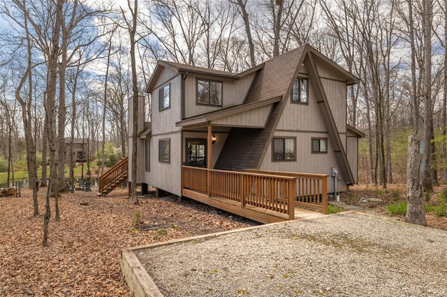 view of home's exterior featuring a shingled roof and stairway