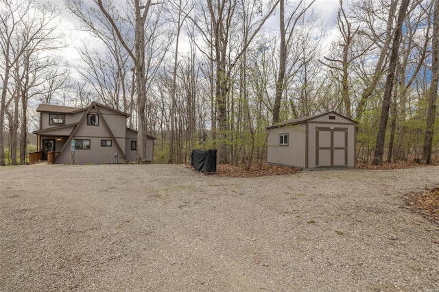 view of yard with a shed, an outbuilding, and driveway