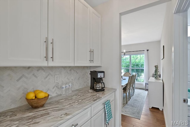 472 Cypress Creek Ln, Imperial, MO 63052 - kitchen featuring white cabinetry, decorative backsplash, hardwood / wood-style flooring, and light stone counters